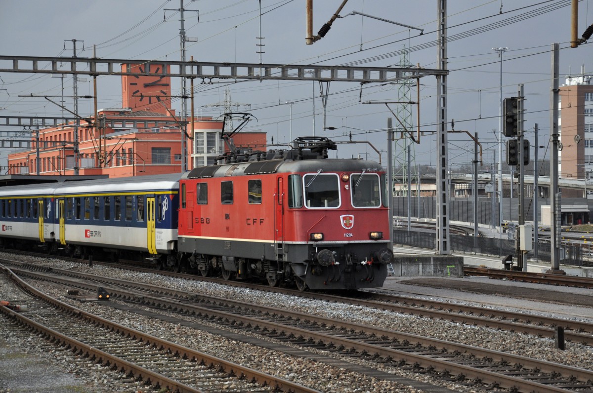 Re 4/4 II 11204 durchfährt den Bahnhof Muttenz. Die Aufnahme stammt vom 07.01.2015.