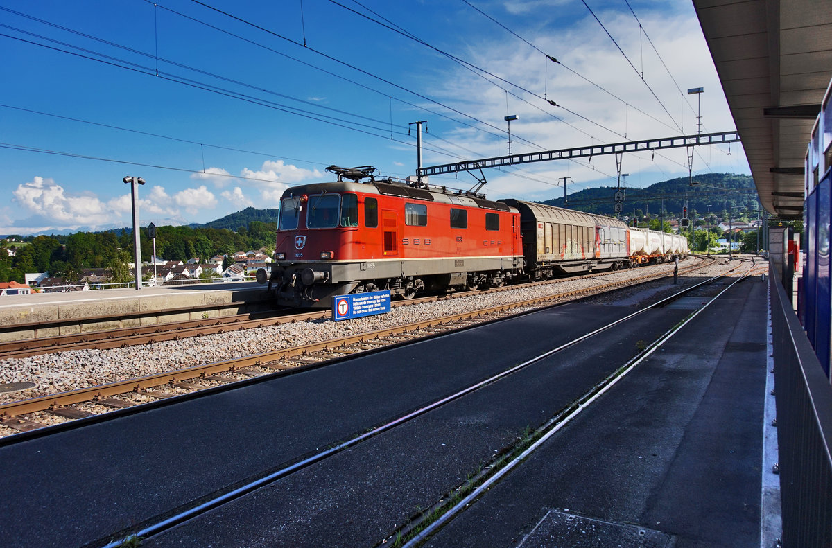 Re 4/4 II 11235 durchfährt mit einem Güterzug den Bahnhof Uzwil, in Richtung Winterthur.
Aufgenommen am 18.7.2016.