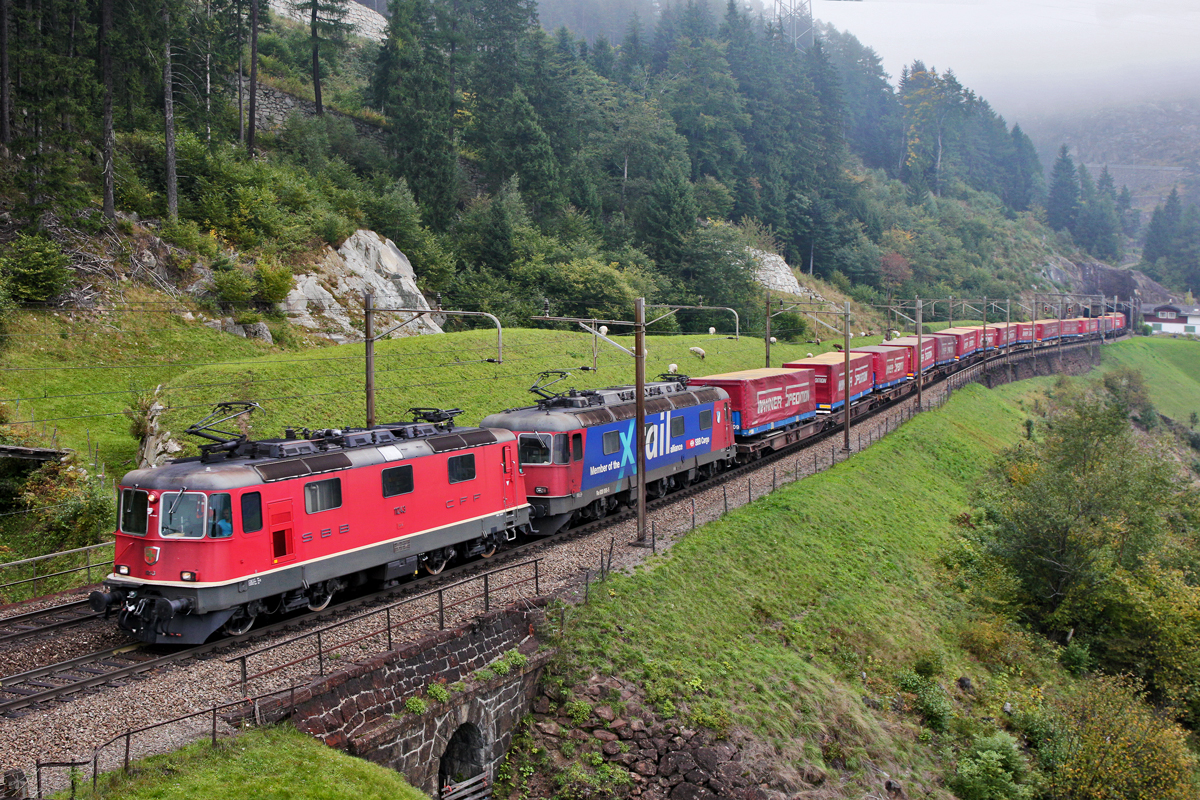 Re 4/4 II 11243 und die Re 620 088-5 X-Rail  Linthal  fahren zusammen mit der Schublok Re 421 384-9 an einem nebligen Herbsttag mit dem  Winnerzug  den Gotthard hinauf.Bild Wassen 3.Ebene September 2015