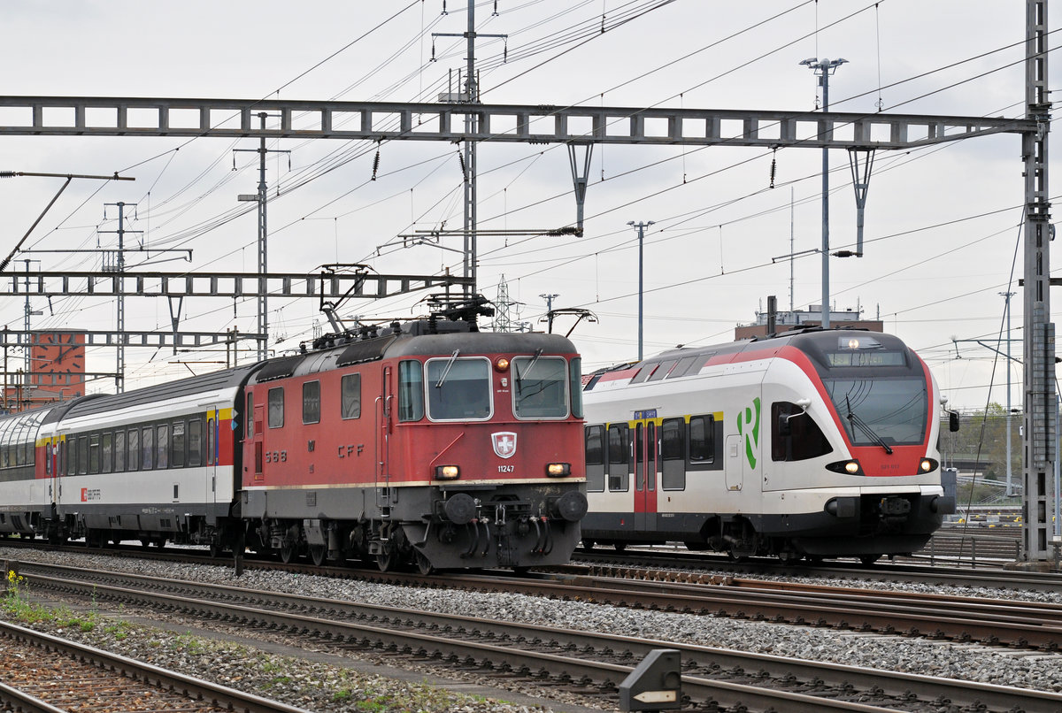 Re 4/4 II 11247 und RABe 521 017 auf der S3 verlassen den Bahnhof Muttenz. Die Aufnahme stammt vom 08.04.2016.