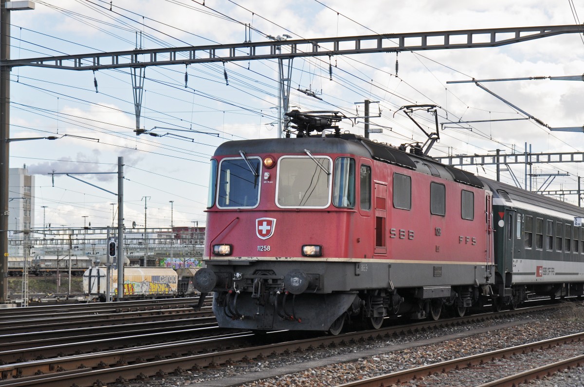 Re 4/4 II 11258 durchfährt den Bahnhof Muttenz. Die Aufnahme stammt vom 11.02.2016.