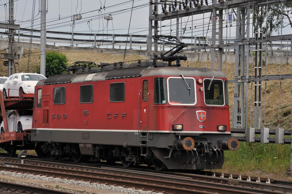 Re 4/4 II 11265 durchfährt den Bahnhof Muttenz. Die Aufnahme stammt vom 17.06.2014.