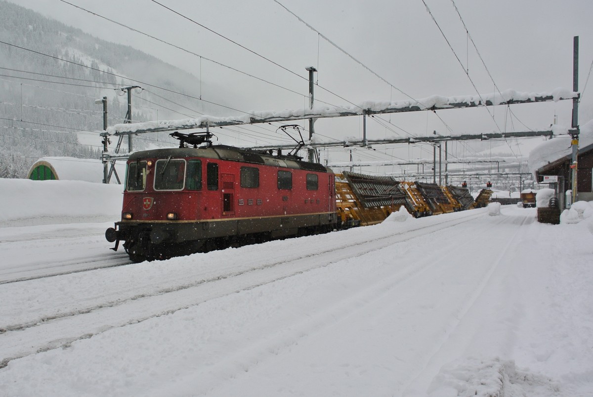 Re 4/4 II 11283 mit Güterzug bei Durchfahrt in Airolo, 07.02.2014.