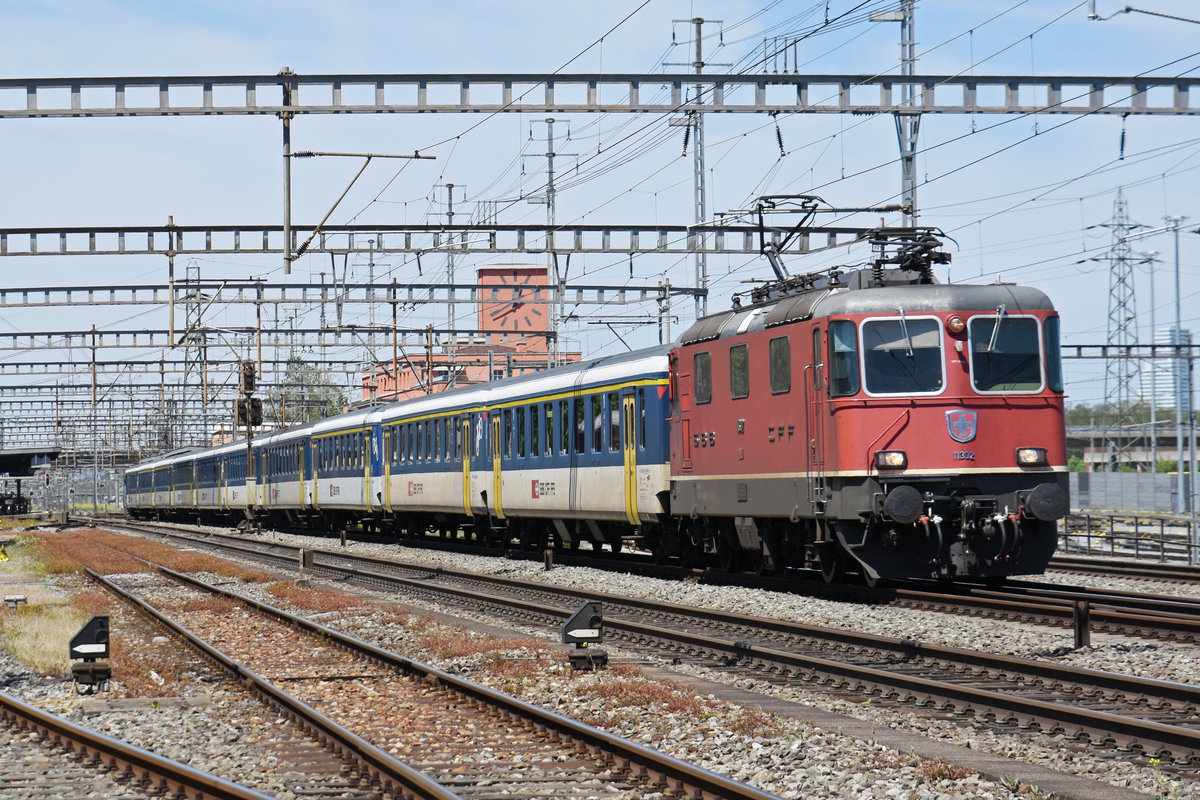 Re 4/4 II 11302 durchfährt den Bahnhof Muttenz. Die Aufnahme stammt vom 14.05.2019.