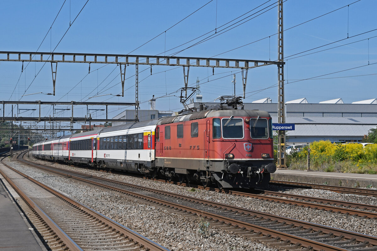 Re 4/4 II 11303 durchfährt am 22.08.2023 den Bahnhof Rupperswil.