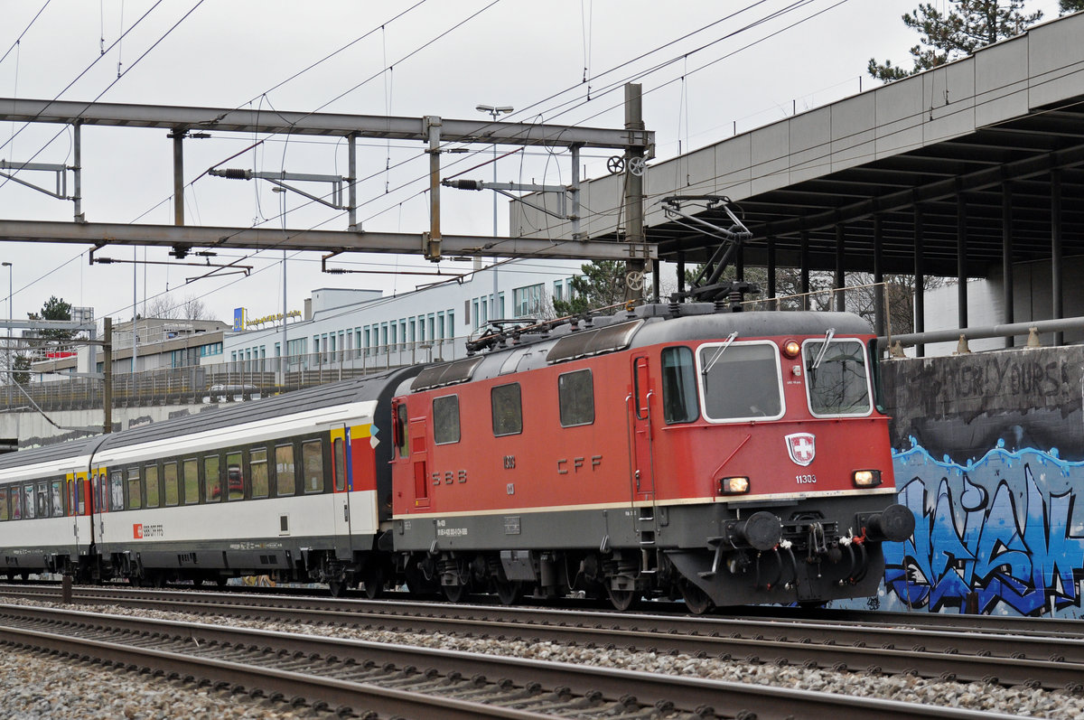 Re 4/4 II 11303 fährt Richtung Bahnhof Muttenz. Die Aufnahme stammt vom 29.01.2018.