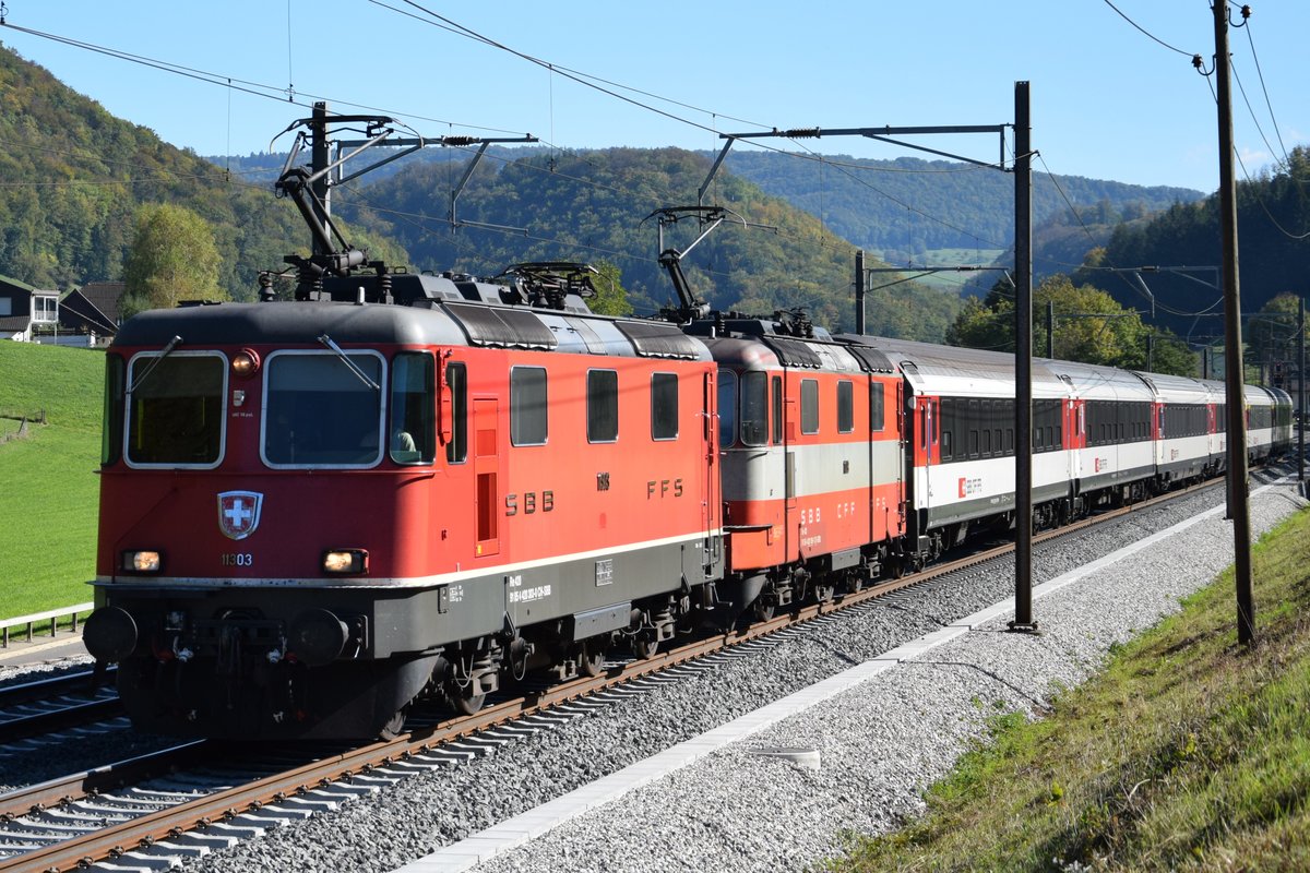 Re 4/4 II 11303 zieht zusammen mit Swiss Express Re 4/4 II 11109 einen IR in Richtung Basel. Aufgenommen bei Tecknau am 05.10.2018.
