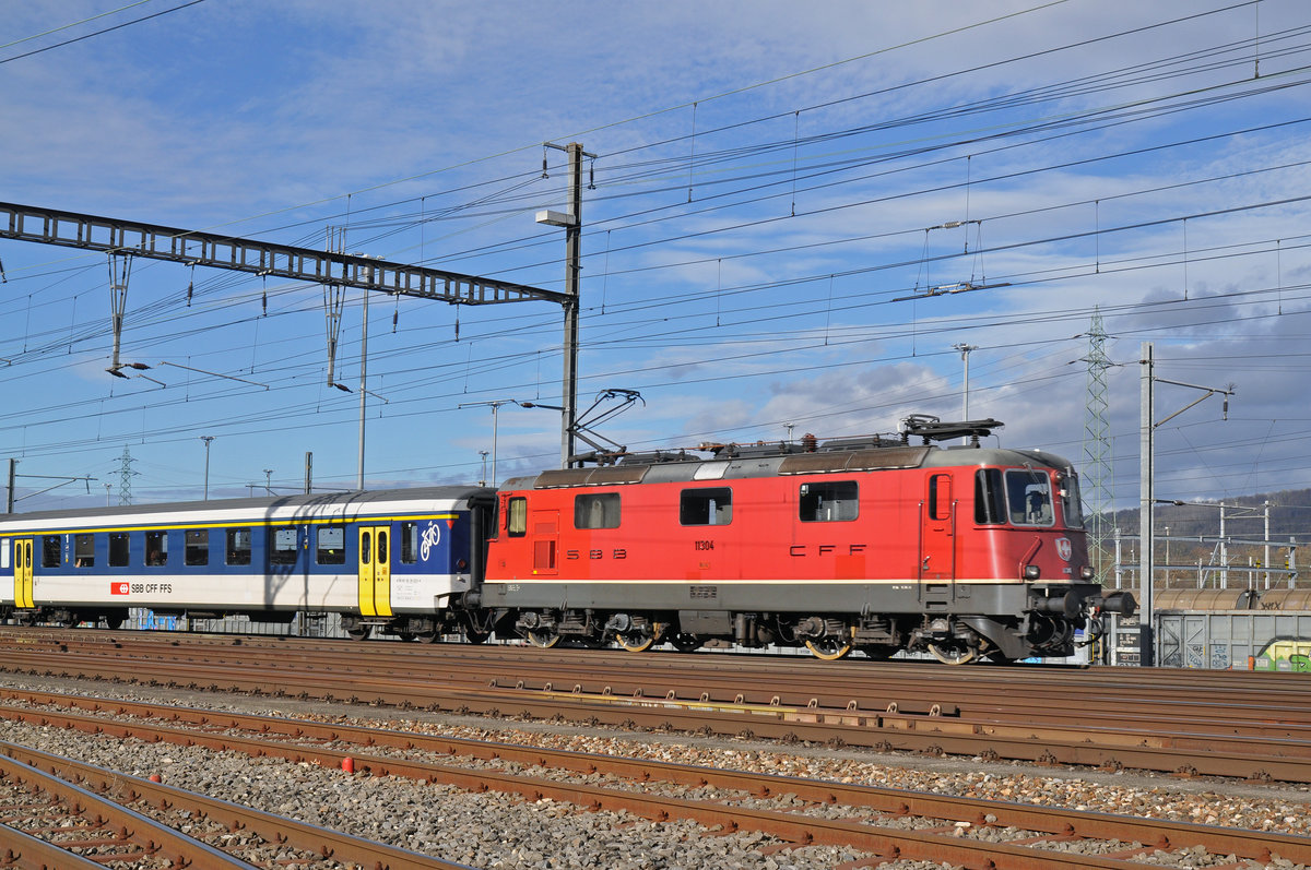 Re 4/4 II 11304 durchfährt den Bahnhof Muttenz. Die Aufnahme stammt vom 19.11.2015.