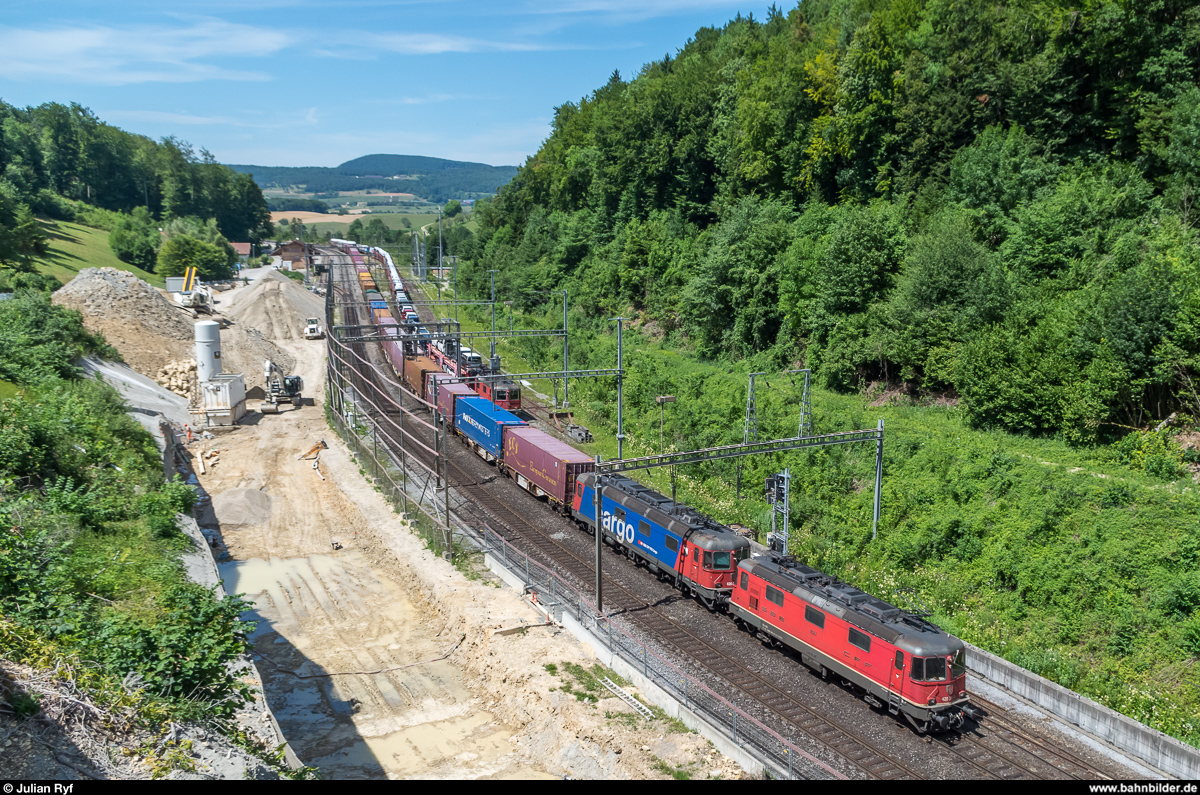 Re 4/4 II 11311 steht am 5. Juli 2017 mit einem Autozug im Bahnhof Effingen und wird gerade von Re 4/4 II 11341 und Re 6/6 11669  Hägendorf  mit einem UKV-Zug überholt. Daneben ist die Baustelle für den neuen Bözbergtunnel zu erkennen.
