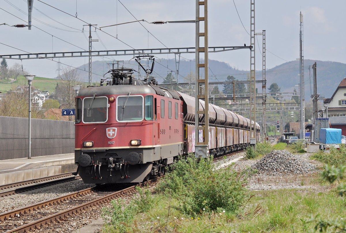 Re 4/4 II 11317 wartet beim Bahnhof Gelterkinden. Die Aufnahme stammt vom 06.04.2017.