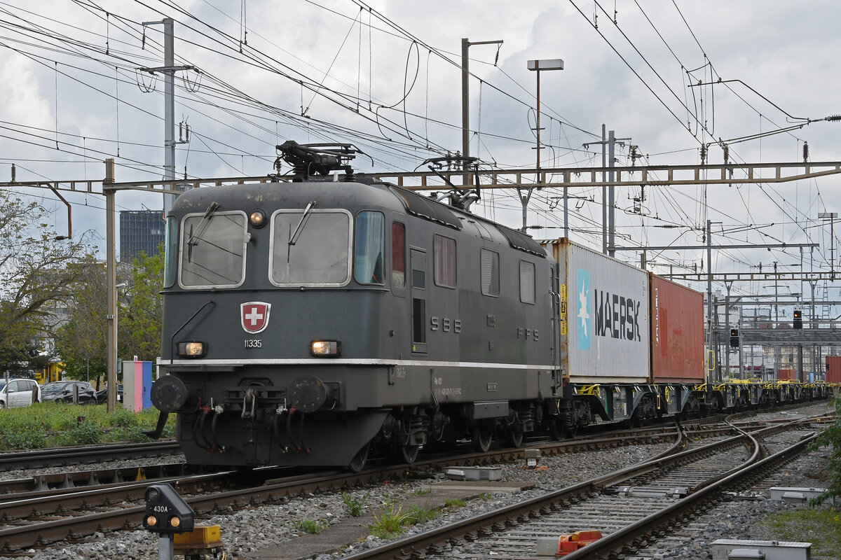 Re 4/4 II 11335 durchfährt am 18.04.2024 den Bahnhof Pratteln.
