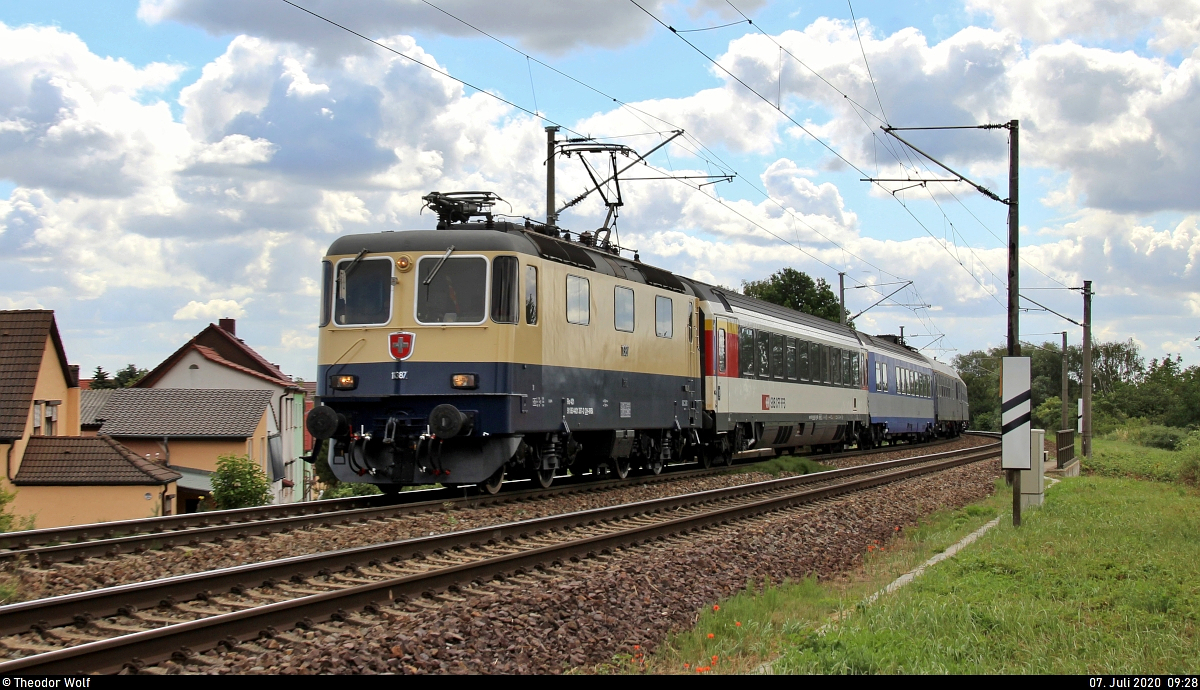 Re 4/4 II 11387 (421 387-2) der International Rolling Stock Investment GmbH (IRSI) als DPE 31469 von Neustrelitz Hbf nach Konstanz fährt mit verschiedenen Personenwagen in Zscherben, Angersdorfer Straße, auf der Bahnstrecke Halle–Hann. Münden (KBS 590). Kennt eigentlich jemand den Anlass dieser Sonderfahrt? [7.7.2020 | 10:28 Uhr]
