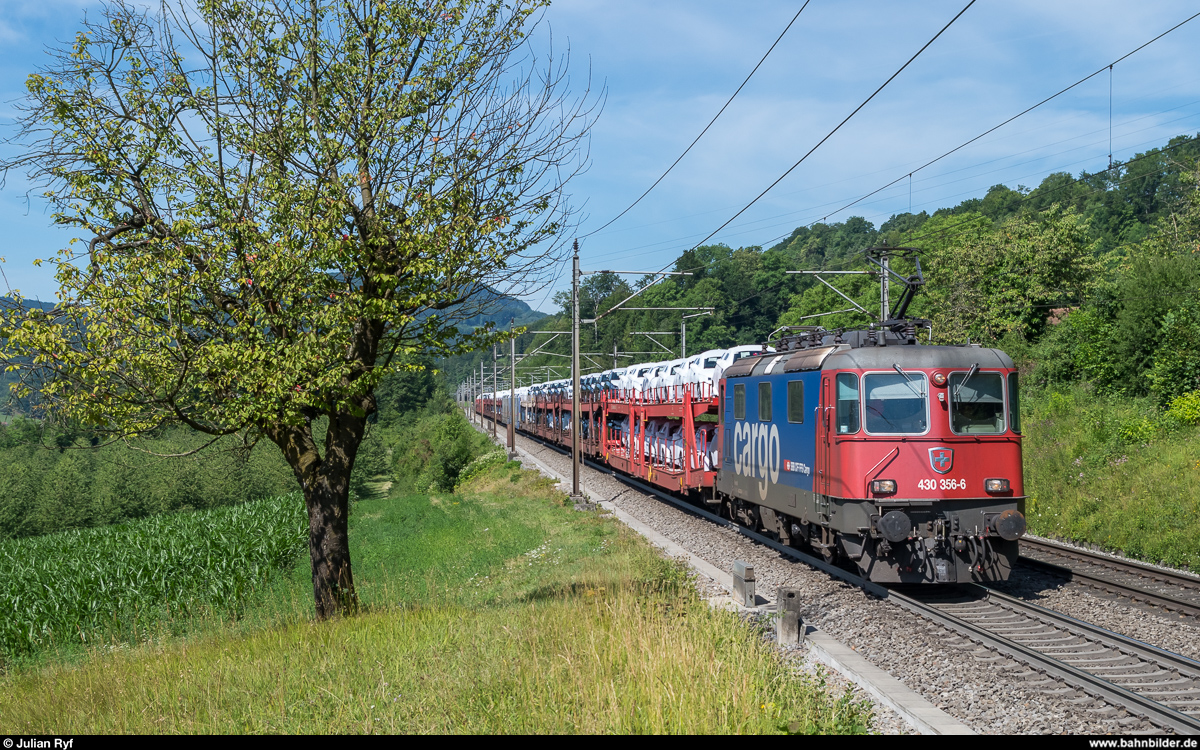 Re 4/4 III 11356 kommt am 5. Juli 2017 mit einem Autozug bei Umiken auf dem falschen Gleis den Bözberg hinunter.