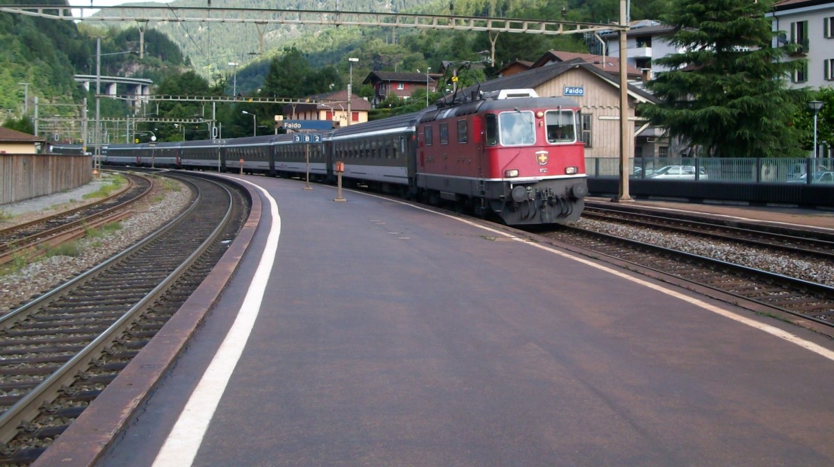 Re 4/4 mit einem IR nach Locarno am 20.7.2011 bei der Einfahrt in Faido.