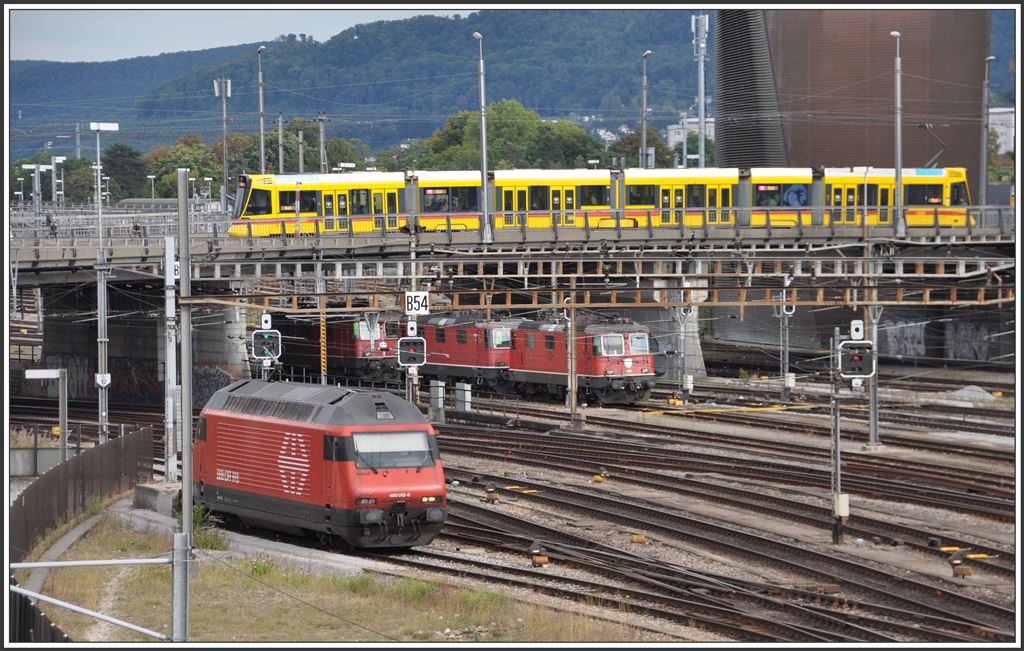 Re 460 013-8 und einige Re 420 warten auf neue Aufgaben und auf der Münchensteinerstrasse überquert ein Be 6/10 Tango der BLT die Geleise beim Bahnhof Basel SBB. (05.09.2015)