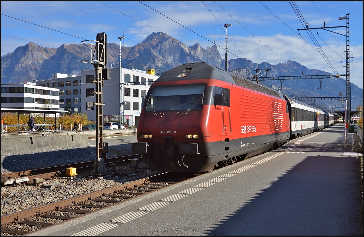 Re 460 019-3 bringt einen IR von Chur nach Zürich. Hier beim Halt in Sargans. Im Hintergrund das Falknismassiv und weiter rechts die Berge, die durch die Erzählungen von Heidi weltberühmt wurden. November 2015.