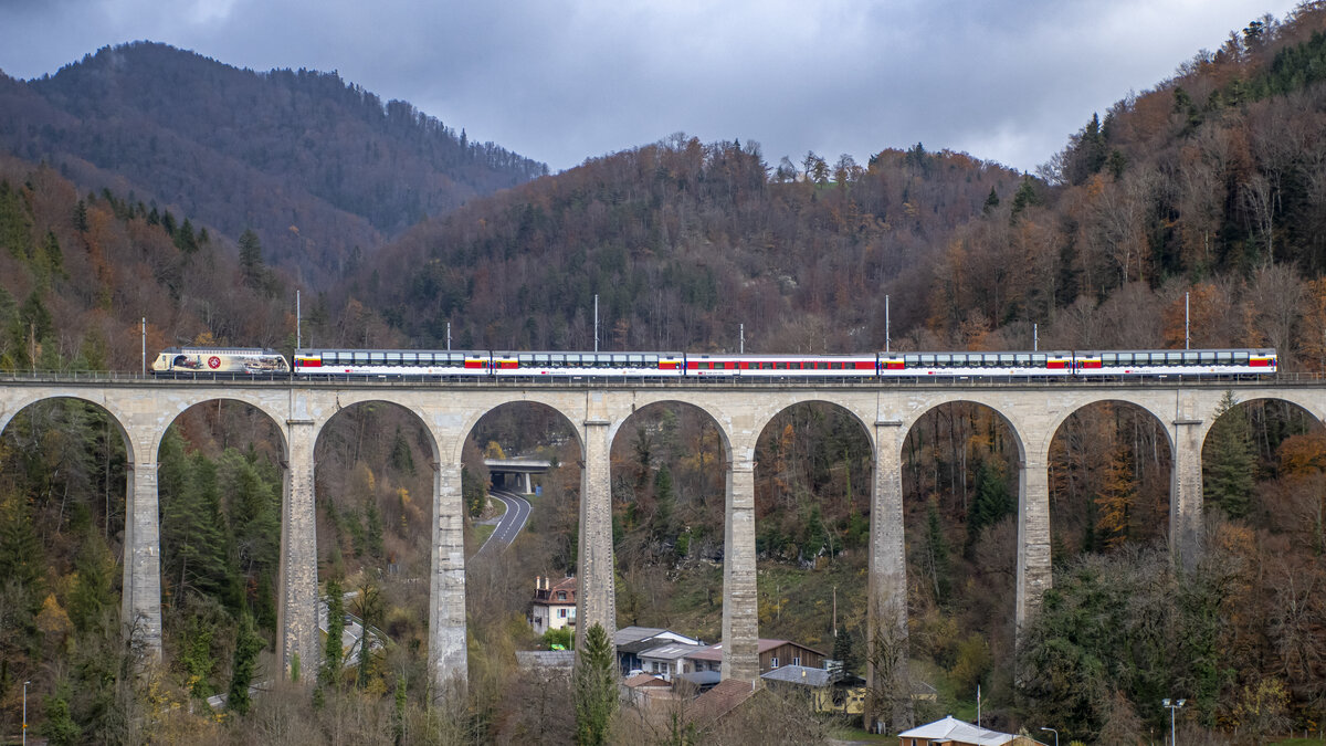Re 460 019-3 überquert aus Basel kommend mit einem Sonderzug nach Bure-Casernes den Viaduc de la Combe Maran in St. Ursanne, aufgenommen am 19.11.2022.