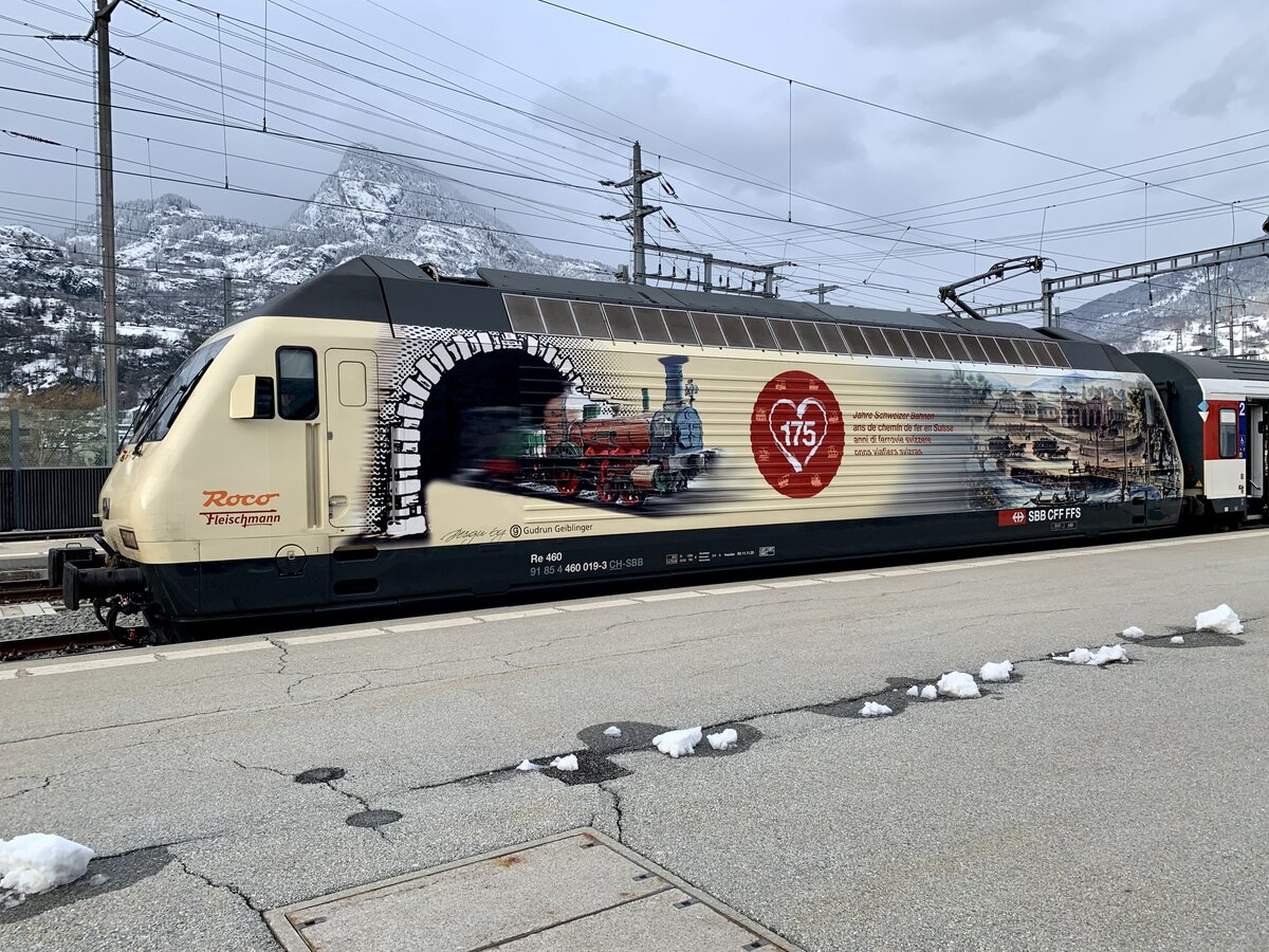 Re 460 019 mit Werbung 175 Jahre Schweizer Bahnen am 2.4.22 im Bahnhof Brig.