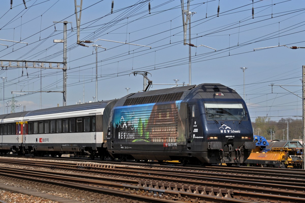 Re 460 023-5 mit der HEV Schewiz Werbung durchfährt den Bahnhof Muttenz. Die Aufnahme stammt vom 13.04.2015.