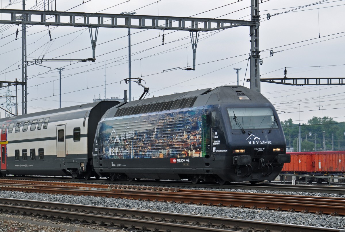 Re 460 023-5 mit der HEV Werbung durchfährt den Bahnhof Muttenz. Die Aufnahme stammt vom 08.06.2015.