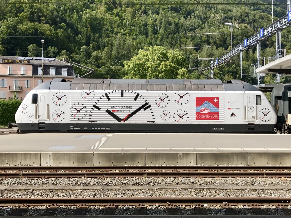 Re 460 044 mit Mondaine Werbung am 19.8.17 im Bhf Interlaken Ost beim warten auf ihre Abfahrt.