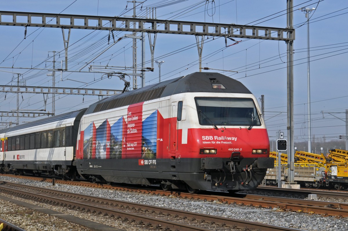 Re 460 048-2 mit der RAIL A WAY Werbung durchfährt den Bahnhof Muttenz. Die Aufnahme stammt vom 13.02.2015.
