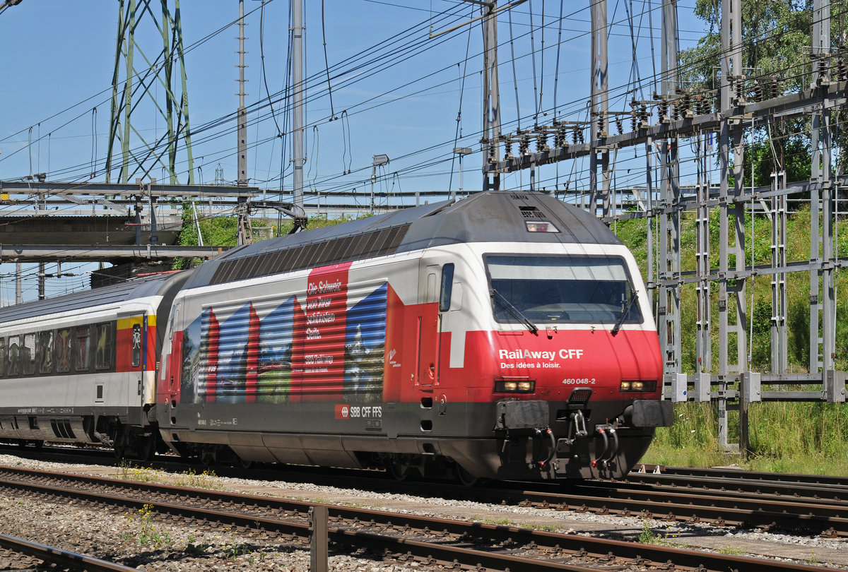 Re 460 048-2, mit der Rail Away Werbung, durchfährt den Bahnhof Muttenz. Die Aufnahme stammt vom 04.07.2016.