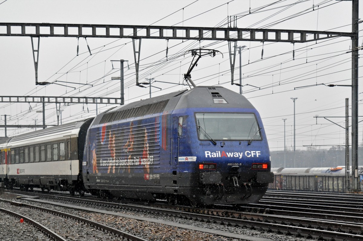 Re 460 050-8 mit der RAIL A WAY Werbung durchfährt bei leichtem Schneefall den Bahnhof Muttenz. Die Aufnahme stammt vom 26.01.2015.