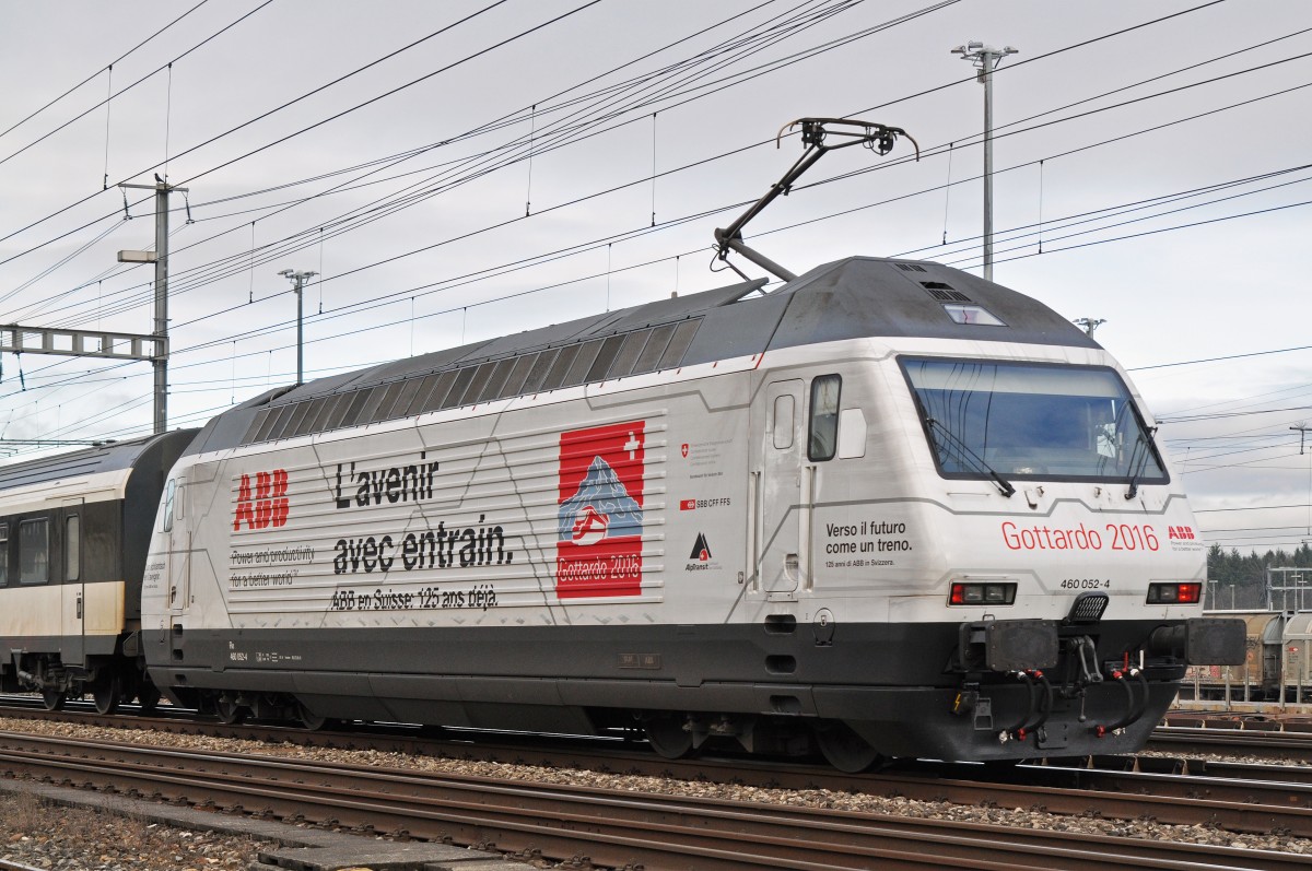 Re 460 052-4 mit einer ABB und Gottardo 2016 Werbung, durchfährt den Bahnhof Muttenz. Die Aufnahme stammt vom 05.02.2016.