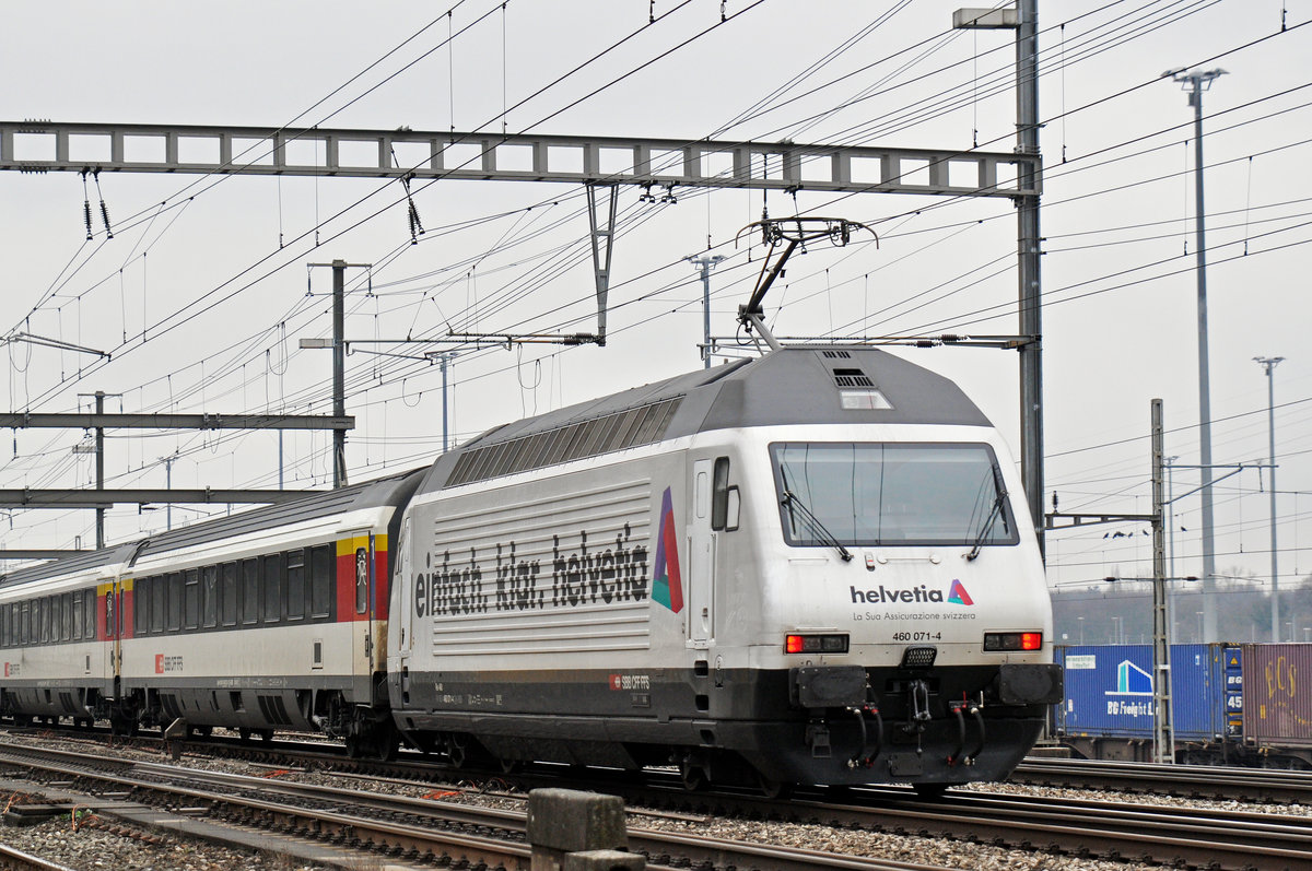 Re 460 071-4, mit der Helvetia Werbung, durchfährt den Bahnhof Muttenz. Die Aufnahme stammt vom 27.01.2018.