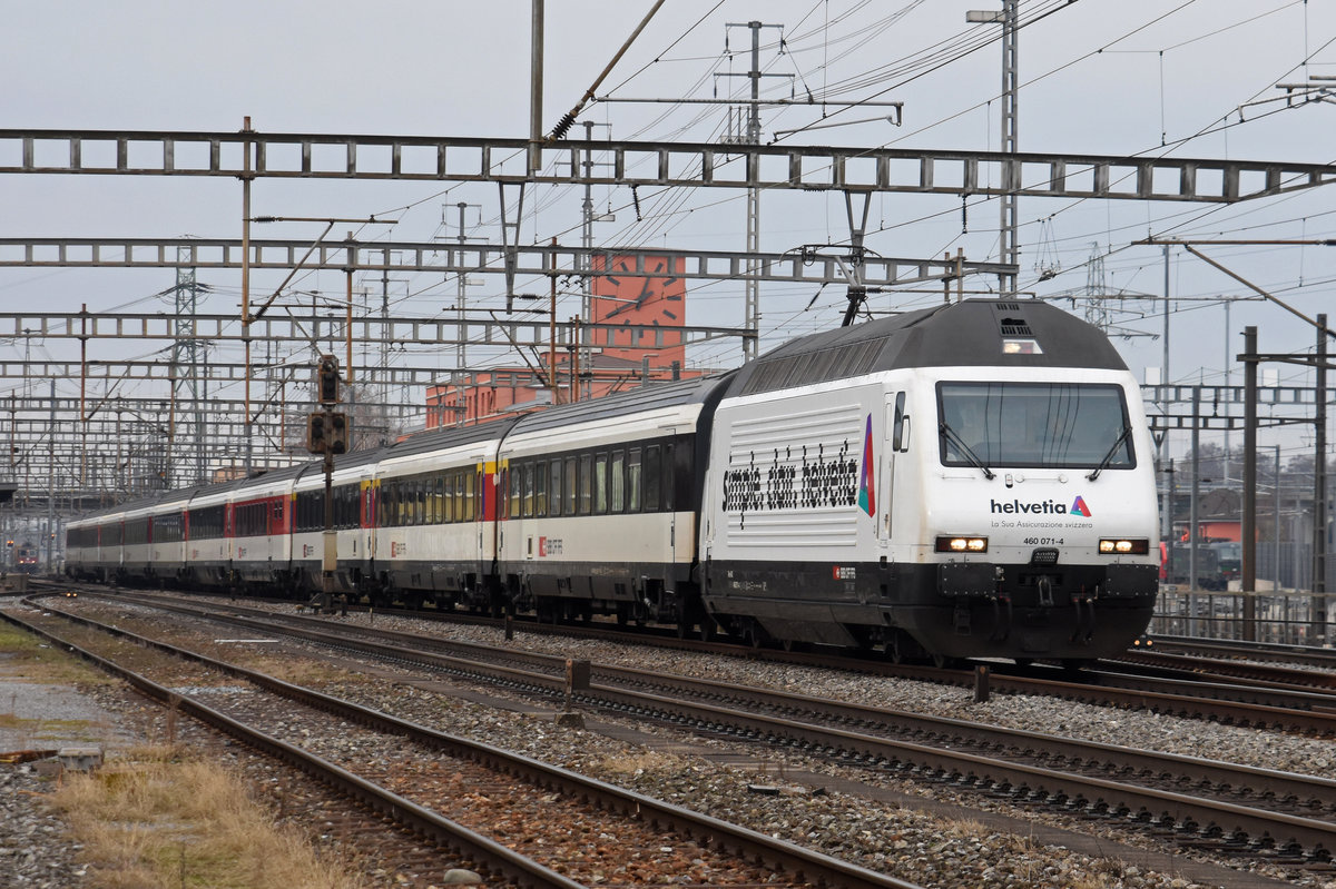 Re 460 071-4 mit der Helvetia Werbung, durchfährt den Bahnhof Muttenz. Die Aufnahme stammt vom 29.11.2018.