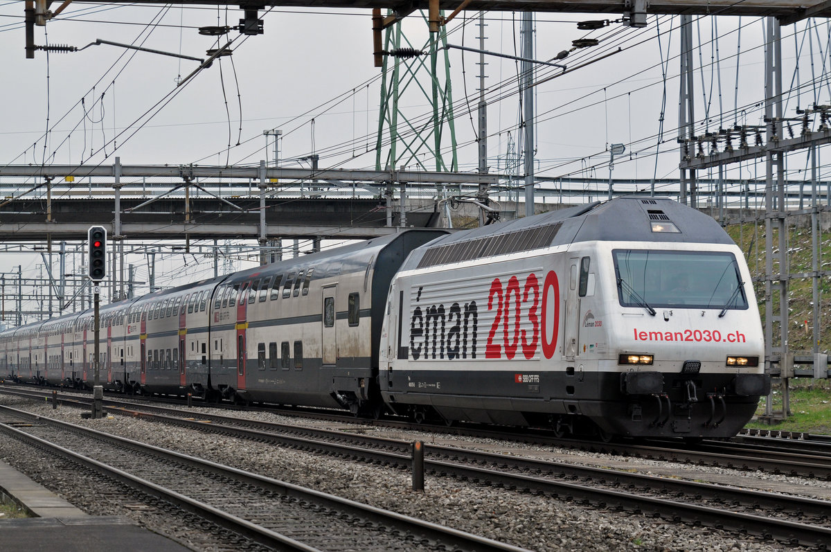 Re 460 075-5, mit der Léman 2030 Werbung, durchfährt den Bahnhof Muttenz. Die Aufnahme stammt vom 20.03.2018.