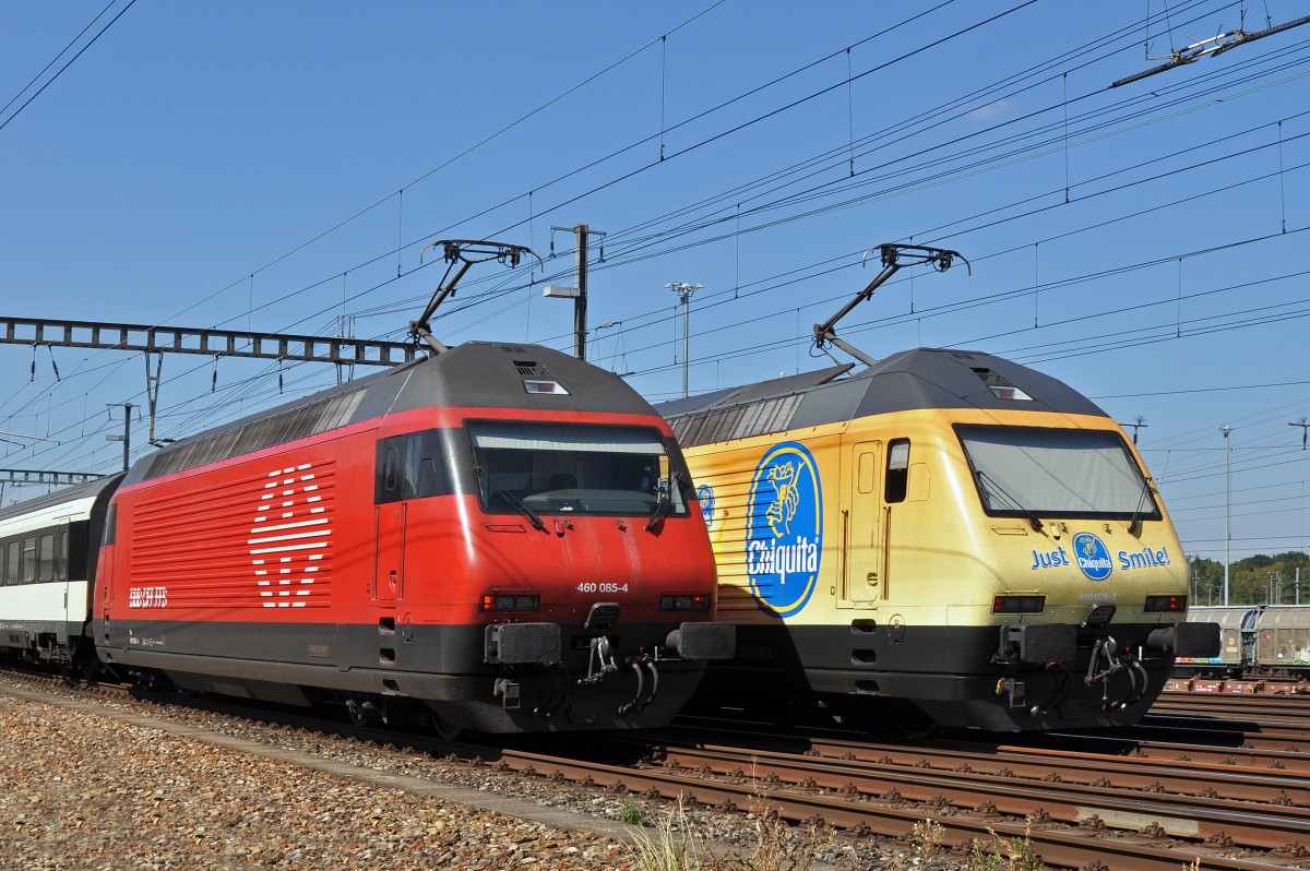 Re 460 085-4 und die Re 460 029-2 mit der Chiquita Werbung durchfahren gleichzeitig den Bahnhof Muttenz. Die Aufnahme stammt vom 10.09.2015.