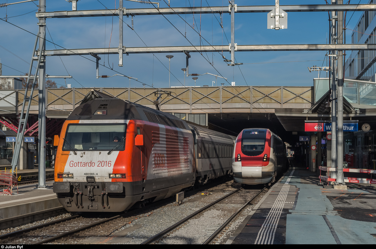 Re 460 085 mit Werbung für Coop/Gottardo2016 verlässt am 9. Dezember 2016 den Bahnhof Winterthur in Richtung Zürich während auf dem Gegengleis gerade ICN RABDe 500 040  Graf Zeppelin  in den Bahnhof einfährt.