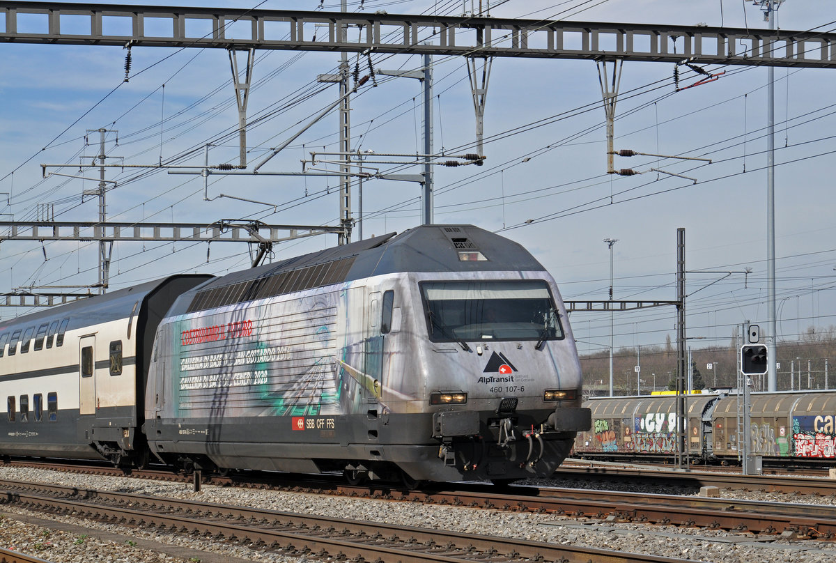 Re 460 107-6, mit der Alp Transit Werbung, durchfährt den Bahnhof Muttenz. Die Aufnahme stammt vom 04.03.2017.