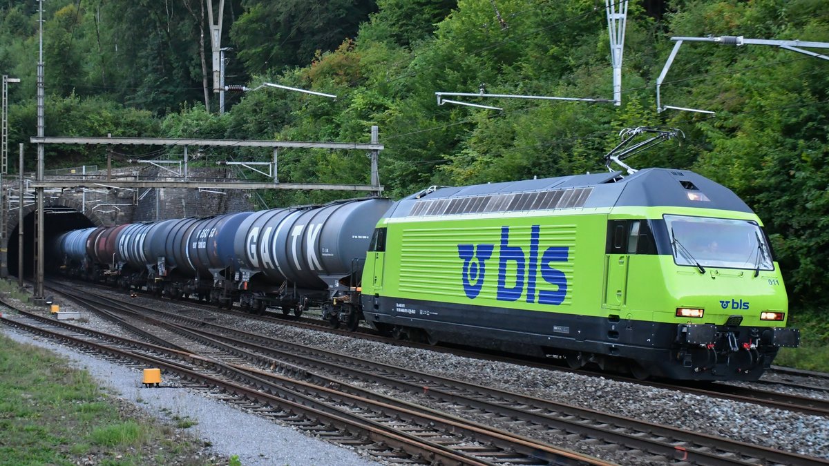 Re 465 011 verlässt mit einem leeren Kesselzug aus St. Triphon gerade den Hauensteintunnel bei Tecknau BL und ist unterwegs in Richtung Basel. Aufgenommen am Abend des 21.08.2020.