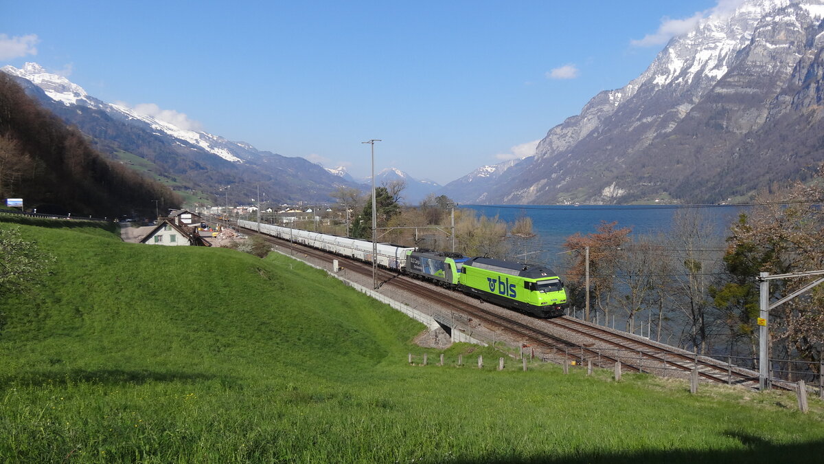 Re 465 018 und Re 485 013 der BLS zogen am 14. April 2021 einen Sandzug nach Zizers, hier bei der Fotostelle in Unterterzen. Im Hintergrund der Walensee und rechts die Churfirsten. 