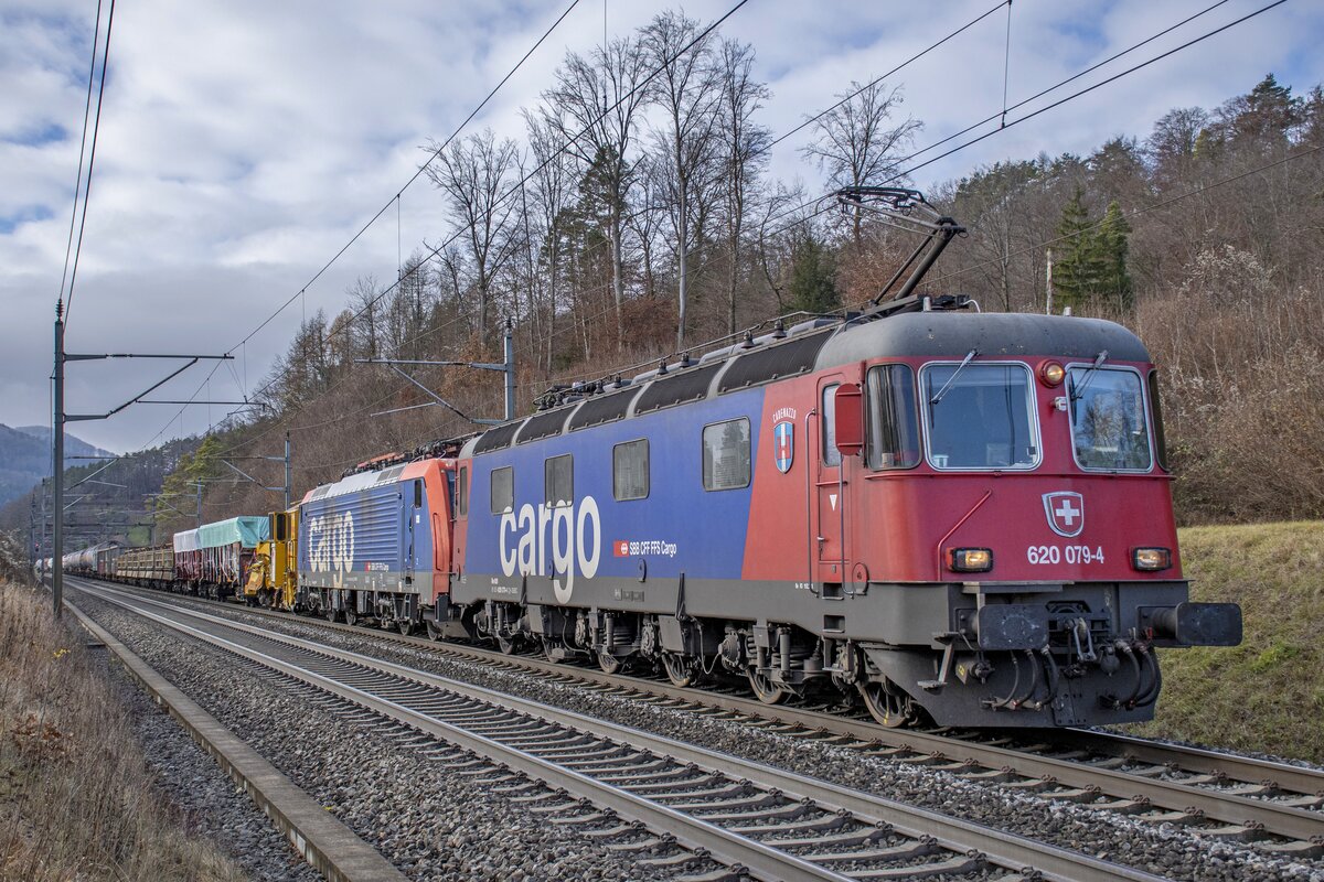 Re 620 079-4  Cadenazzo  hat 474 013 im Schlepptau und ist samt Güterzug bei Villnachern AG in Richtung Tessin unterwegs, aufgenommen am 06.12.2021.