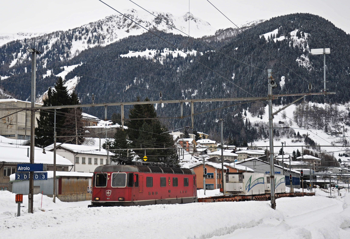 Re 6/6 11648  Aigle  erreicht mit ihrem Güterzug bestehend aus fünf Taschenwagen den tiefverschneiten Bahnhof Airolo. Aufgenommen am 23.02.2015