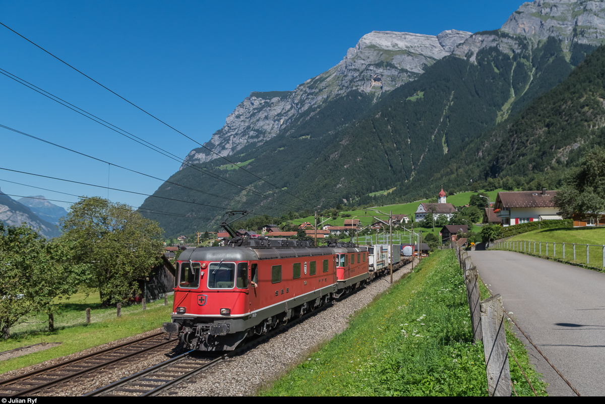 Re 6/6 11676  Zurzach  ist am 25. August 2016 zwar erstaunlich sauber, dafür fehlt ihr die Loknummer an der Front. Gemeinsam mit einer Re 4/4 II zieht sie bei Silenen einen UKV-Zug bergwärts.