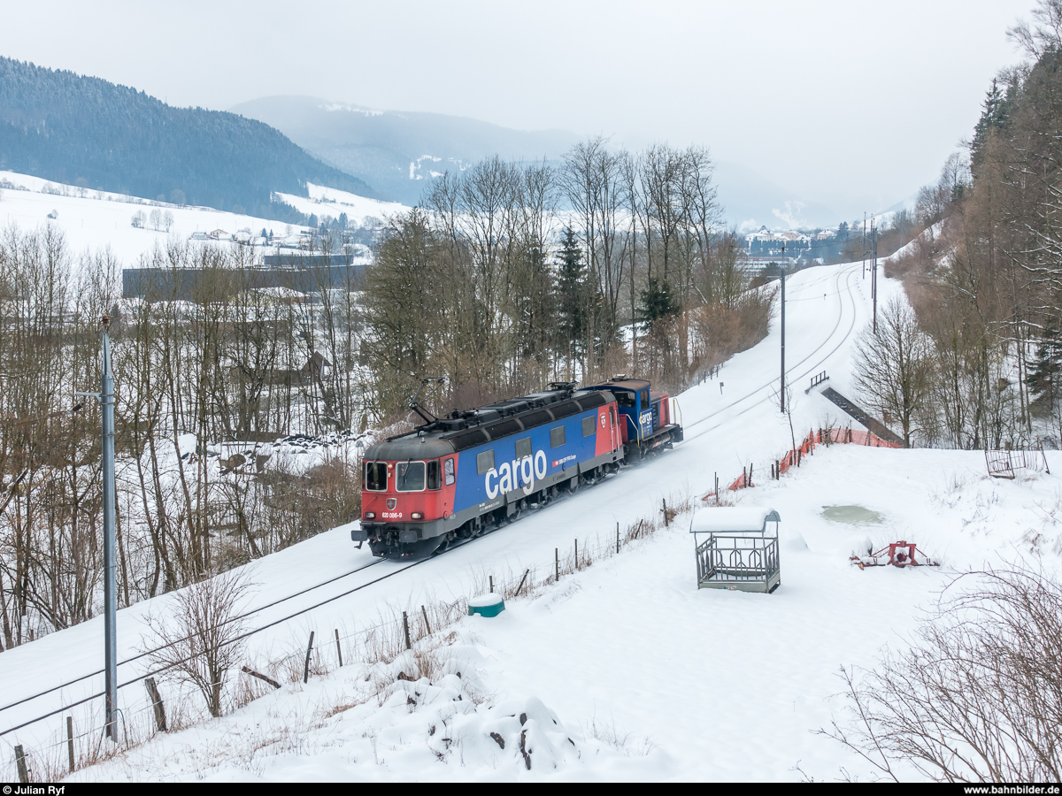 Re 6/6 11686 mit einem Tm 232 am Haken am 3. März 2018 unterwegs von Les Verrières nach Biel zwischen Couvet CFF und Travers.