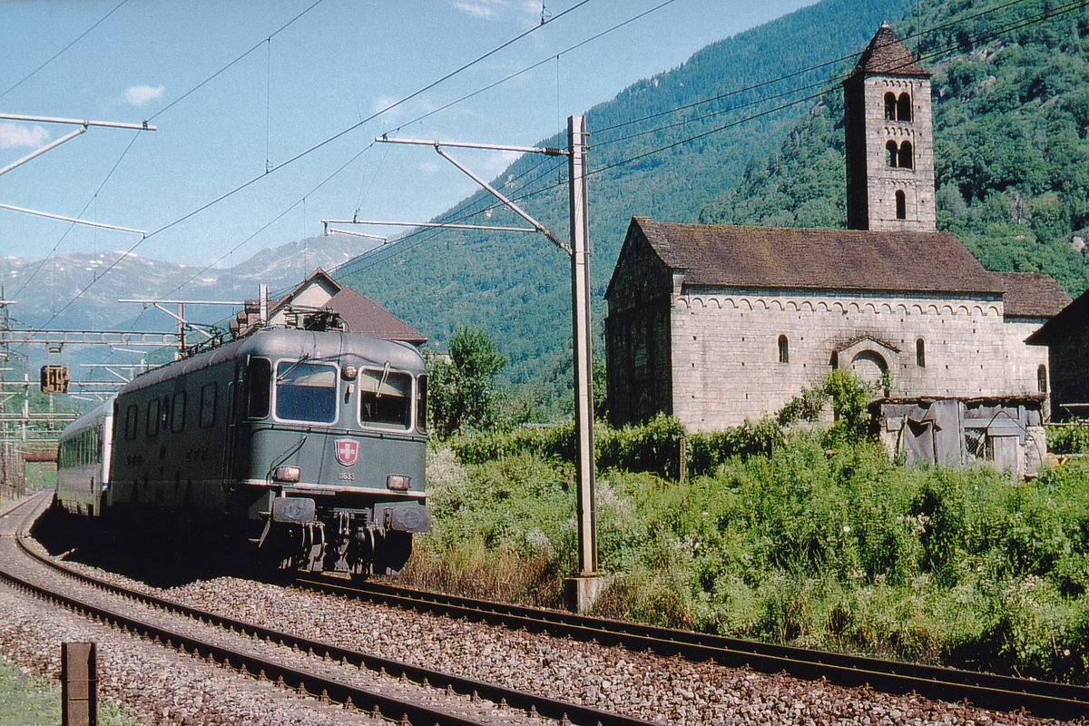 Re 6/6 im Personenverkehr.
Re 6/6 11633  MURI  beim Passieren der Kirche San Niccolo in Giornico im Juli 2001.
Fotostandort ausserhalb dem Bereich der Geleise. Bildausschnitt Fotoshop.
Foto: Walter Ruetsch