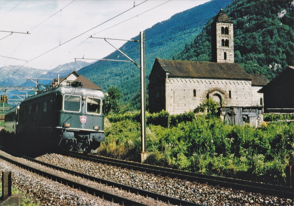 Re 6/6 im Personenverkehr.
Re 6/6 11660  TAVANNES  beim Passieren der Kirche San Niccolo in Giornico im Juli 2001.
Fotostandort ausserhalb dem Bereich der Geleise. Bildausschnitt Fotoshop.
Foto: Walter Ruetsch