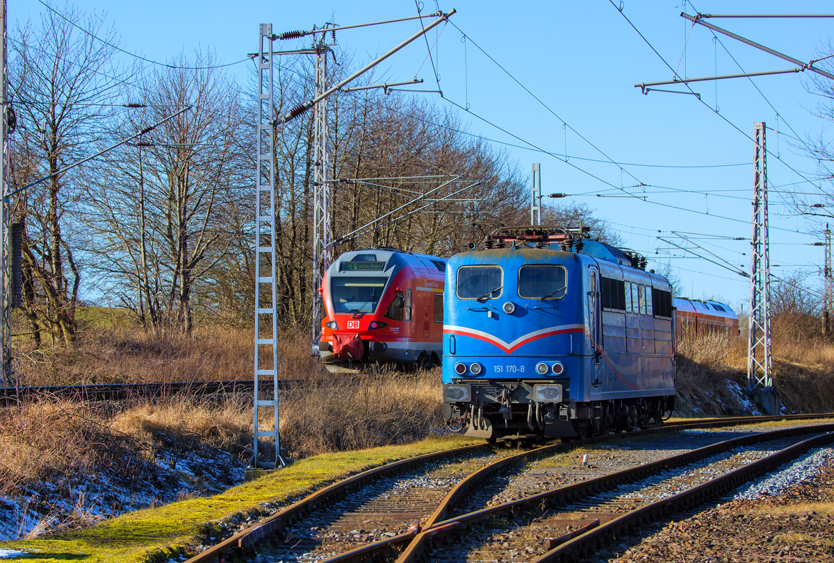 RE 9 fährt in Sassnitz Lancken an der EGP Lok 151 170 vorbei, die im Anschluss Kreidewerk auf das Ende der Beladung von Kreidewagen wartet. - 24.02.2017
