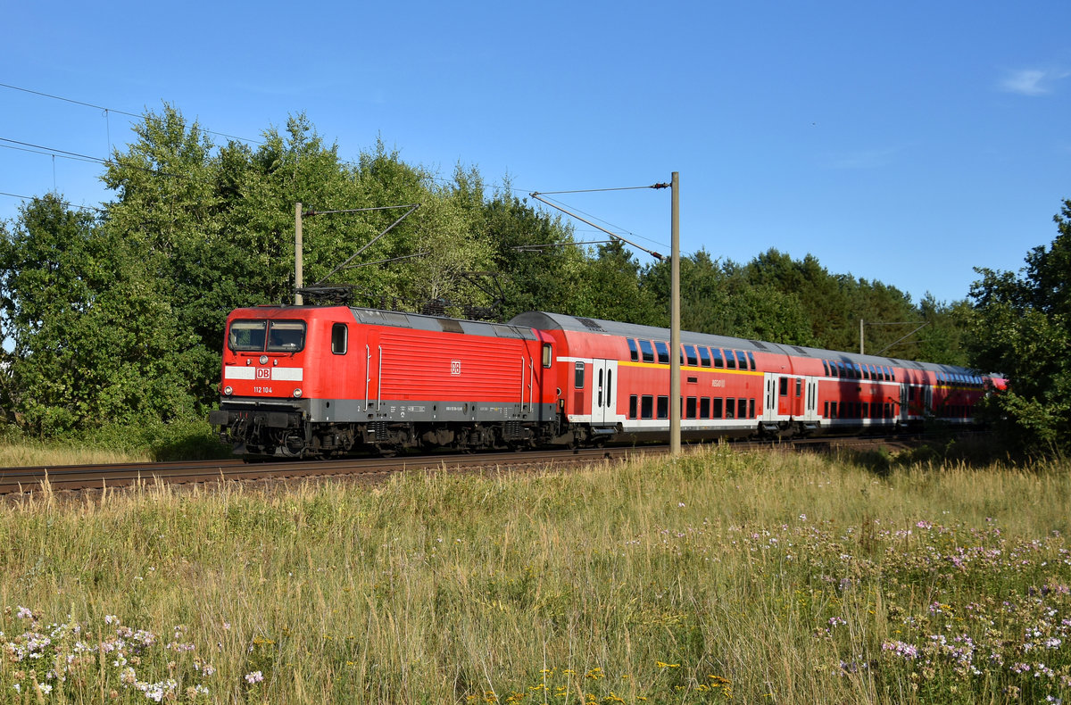 RE1 des Hanse-Express mit der 112 104-5 in Front, kurz vor der Einfahrt am Bahnhof Büchen. 3km östlich von Büchen, 06.08.2018.