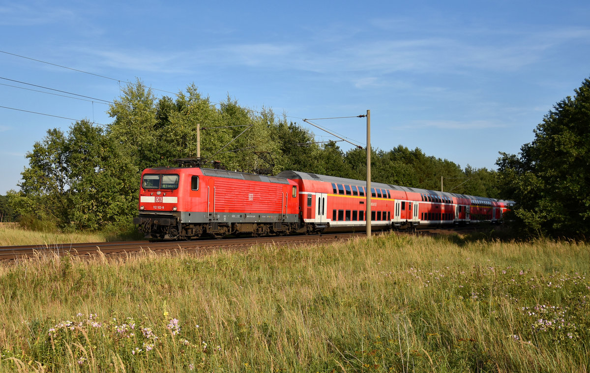 RE1 des Hanse-Express mit der 112 102-9 in Front, kurz vor der Einfahrt am Bahnhof Büchen. 3km östlich von Büchen, 16.08.2018.