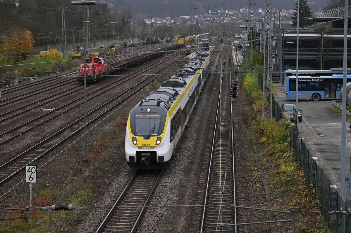 RE10a nach Mannheim verlässt Neckarelz am 24.11.2020, der Zug ist aus zwei dreiteiligen Abellio Hamstern gebildet. Im Hintergrund links steht die SGL 261 313 mit einem Bauzug.