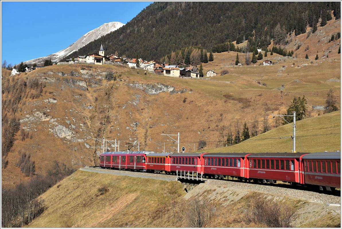 RE1129 in der Doppelkurve oberhalb Bergün. Am gegenüberliegenden Hang an bester Aussichtslage liegt das schmucke Bündner Dorf Latsch, mit dem Postauto ab Bergün zu erreichen. (07.12.2016)