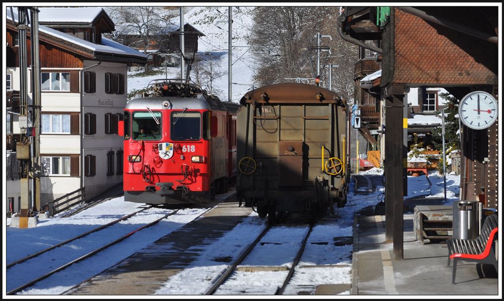 RE1335 nach St.Moritz mit Ge 4/4 II 618  Bergün/Bravuogn  kreuzt in Klosters Dorf um die Mittagszeit einen Güterzug. (29.11.2013)