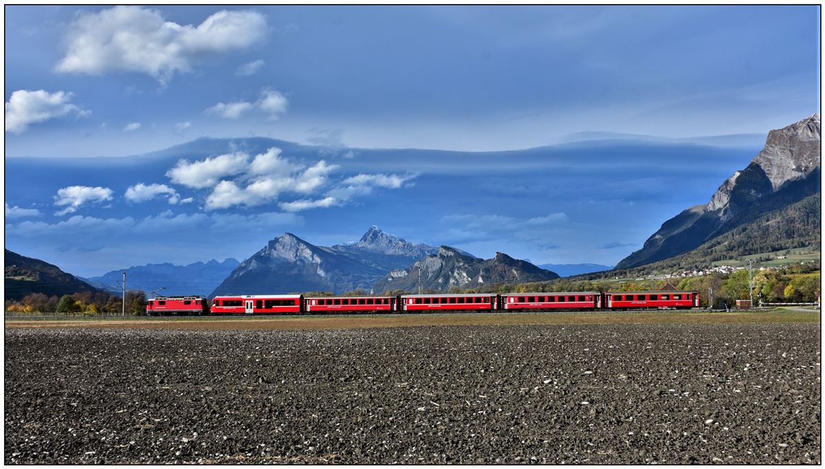 RE1438 mit Ge 4/4 II 612  Thusis  und ein neuer Bt aus St.Moritz bei Malans. Eine phantastische Föhnstimmung hängt über dem Gonzen, der Gauschla und dem Regitzerspitz.(31.10.2018)